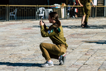 Jerusalem Israel June 19, 2019 View of young Israeli woman soldier having fun front the Western wall at the Old city of Jerusalem in the afternoonのeditorial素材