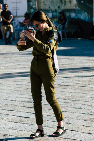 Jerusalem Israel June 19, 2019 View of young Israeli woman soldier having fun front the Western wall at the Old city of Jerusalem in the afternoonのeditorial素材