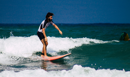 Tel Aviv Israel July 9, 2019 View of unknown Israeli people practicing surfing on Tel Aviv beach in the morningのeditorial素材