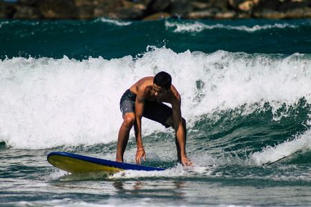Tel Aviv Israel July 9, 2019 View of unknown Israeli people practicing surfing on Tel Aviv beach in the morningのeditorial素材