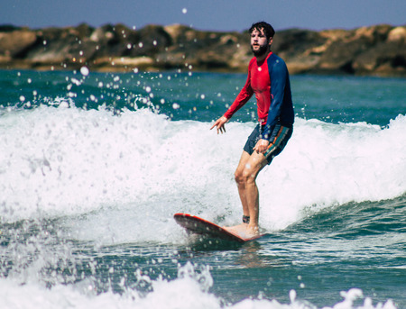Tel Aviv Israel July 9, 2019 View of unknown Israeli people practicing surfing on Tel Aviv beach in the morningのeditorial素材