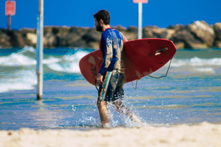 Tel Aviv Israel July 9, 2019 View of unknown Israeli people practicing surfing on Tel Aviv beach in the morningのeditorial素材