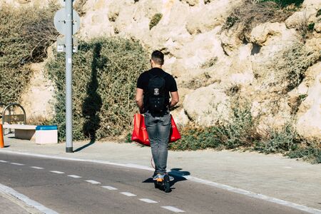 Tel Aviv Israel December 22, 2019 View of unidentified people rolling with a electric scooter in the streets of Tel Aviv in the afternoonの写真素材