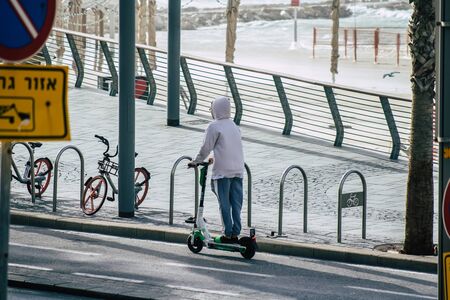 Tel Aviv Israel December 25, 2019 View of unidentified people rolling with a electric scooter in the streets of Tel Aviv in the afternoonの写真素材