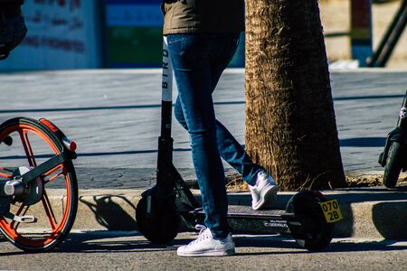 Tel Aviv Israel January 06, 2020 View of unidentified people rolling with an electric scooter in the streets of Tel Aviv in winterの写真素材