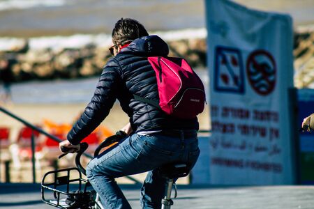 Tel Aviv Israel January 06, 2020 View of unidentified people rolling with a bicycle in the streets of Tel Aviv in winterの写真素材