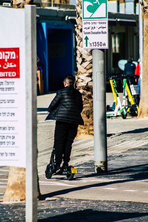 Tel Aviv Israel January 26, 2020 View of unidentified people rolling with an electric scooter in the streets of Tel Aviv in winterの写真素材