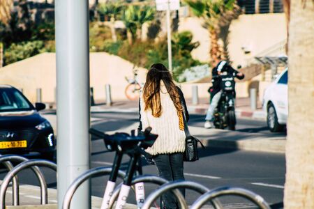 Tel Aviv Israel January 29, 2020 View of unidentified people rolling with an electric scooter in the streets of Tel Aviv in winterの写真素材