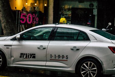 Tel Aviv Israel February 19, 2020 View of traditional Israeli taxi rolling in the streets of Tel Aviv during a raining day in winterの写真素材