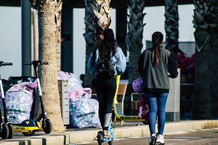 Tel Aviv Israel February 28, 2020 View of unidentified people rolling with an electric scooter in the streets of Tel Aviv during a sunny day in winterの写真素材