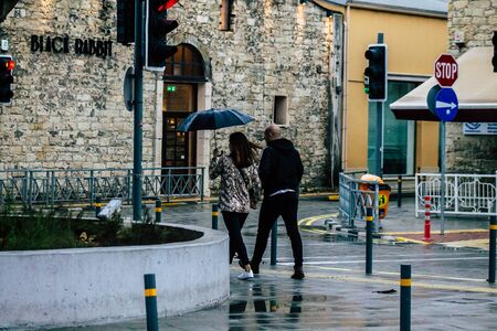 Limassol Cyprus March 12, 2020 View of unidentified people walking in the streets of Limassol during a raining dayの写真素材