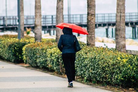 Limassol Cyprus March 12, 2020 View of unidentified people walking in the streets of Limassol during a raining dayの写真素材