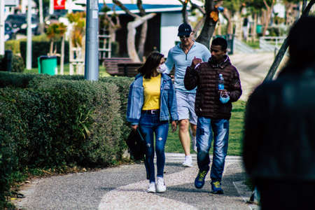 Limassol Cyprus March 16, 2020 View of an unidentified people with a face mask to protect themselves from the coronavirus walking in the street of Limassol in the afternoonのeditorial素材