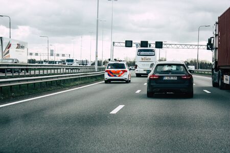 Rotterdam Netherlands March 18, 2019 View of a Dutch police car rolling in the highway in the afternoonの写真素材