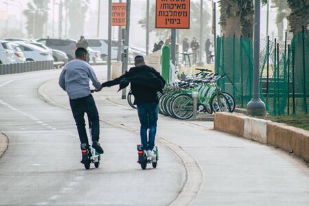 Tel Aviv Israel December 25, 2019 View of unidentified people rolling with a electric scooter in the streets of Tel Aviv in the afternoonの写真素材