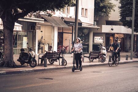 Tel Aviv Israel November 14, 2019 View of unknown Israeli people rolling with a electric scooter in the streets of Tel Aviv in the afternoonの写真素材