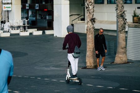 Tel Aviv Israel December 04, 2019 View of unknown Israeli people rolling with a electric scooter in the streets of Tel Aviv in the afternoonの写真素材