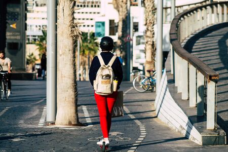 Tel Aviv Israel December 04, 2019 View of unknown Israeli people rolling with a electric scooter in the streets of Tel Aviv in the afternoonの写真素材