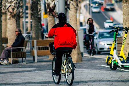 Tel Aviv Israel February 04, 2020 View of unidentified people rolling with a bicycle in the streets of Tel Aviv in winterの写真素材
