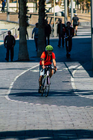 00211 Tel Aviv Israel February 13, 2020 View of unidentified people rolling with a bicycle in the streets of Tel Aviv during a sunny day in winterのeditorial素材