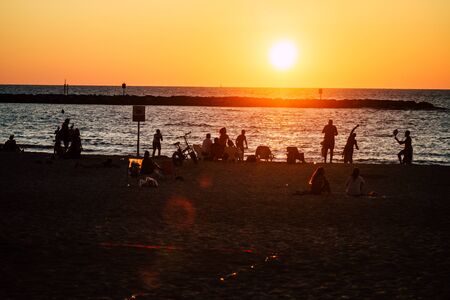 Tel Aviv Israel October 04, 2019 View of unknowns people having fun on the beach of Tel Aviv during the sunsetの写真素材