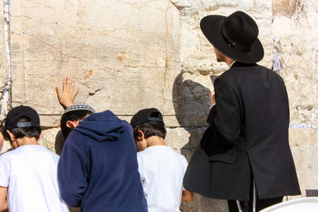 Jerusalem Israel May 14, 2018 Unknowns people and kids praying front the Western wall in the old city of Jerusalem in the eveningのeditorial素材