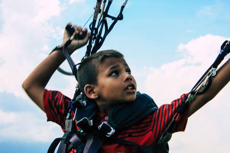 Pokhara Nepal October 6, 2018 Portrait of a young Nepali kid learning to be a paragliding pilot in the landing area front the Phewa lake of Pokharaのeditorial素材