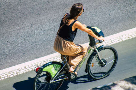 Lisbon Portugal july 25, 2020 View of unidentified woman rolling with a bicycle in the streets of Lisbon, the hilly coastal capital city of Portugal and one of the oldest cities in Europeの写真素材