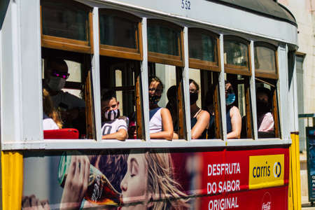 Lisbon Portugal july 26, 2020 View of a traditional old electric tram for passengers driving through the streets and part of the public transport system of Lisbon, the coastal capital city of Portugalの写真素材