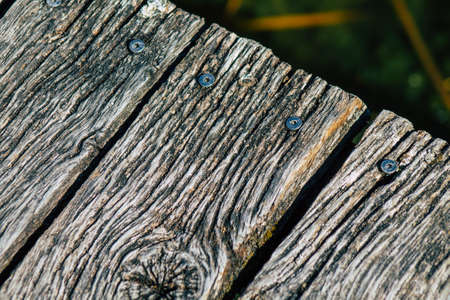 Closeup of a rustic wooden bridge spanning a pond in the french countryside in the fallの写真素材