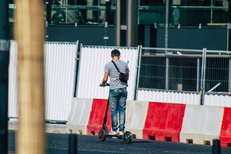 Reims France September 12, 2020 View of unidentified people rolling with an electric scooter in the streets of Reims, operating with a small utility internal combustion engines and a deck in the centerのeditorial素材