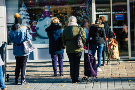 Reims France January 09, 2021 View of unidentified people with a face mask shopping at the market in downtown during Coronavirus outbreak and lockdown to enforce containment of the populationのeditorial素材