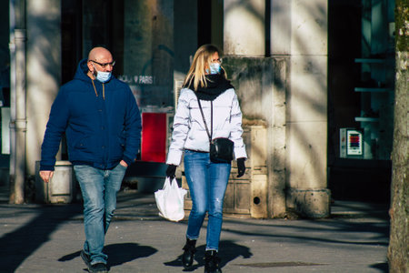 Reims France January 09, 2021 View of unidentified pedestrian with a face mask to protect themself from the coronavirus walking in the streets of Reims during the pandemic affecting Franceのeditorial素材