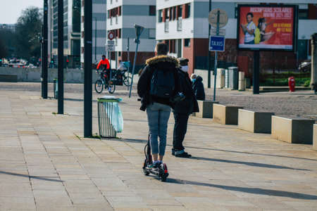 Reims France February 20, 2021 People rolling with an electric scooter in the streets of Reims, operating with a small utility internal combustion engines and a deck in the centerのeditorial素材