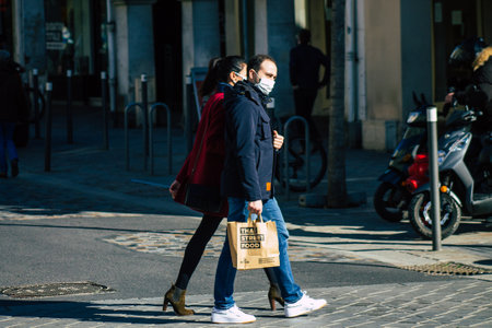 Reims France February 27, 2021 Unidentified pedestrians with a face mask to protect themself from the coronavirus walking in the streets of Reims during the pandemic affecting Franceのeditorial素材