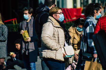 Reims France February 27, 2021 Unidentified pedestrians with a face mask to protect themself from the coronavirus walking in the streets of Reims during the pandemic affecting Franceのeditorial素材