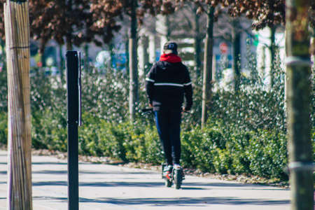 Reims France March 03, 2021 People rolling with an electric scooter in the streets of Reims, operating with a small utility internal combustion engines and a deck in the centerのeditorial素材