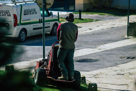 Reims France April 08, 2021 Gardener standing on a small lawn mower in early spring in a public park...