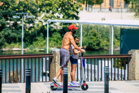 Seville Spain July 06, 2021 People rolling with an electric scooter in the streets of Seville, operating with a small utility internal combustion engines and a deck in the centerの写真素材