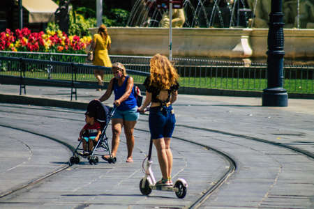 Seville Spain July 06, 2021 People rolling with an electric scooter in the streets of Seville,...