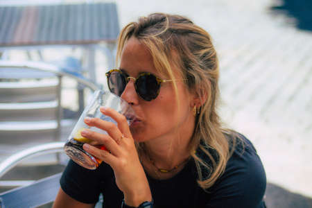 Carmona Spain July 15, 2021 Unidentified tourist without face mask drinking a glass en having fun in summertime at Al Angelus Divinoteca, a unique tapas bar located inside the old Carmona food marketのeditorial素材