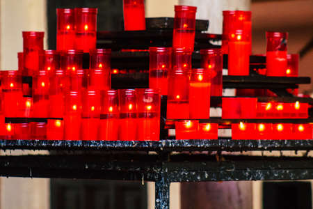 Seville Spain July 23, 2021 Red candles inside a church in Seville, believers light candles as a sign of devotion and pray for Jesus or Maryのeditorial素材