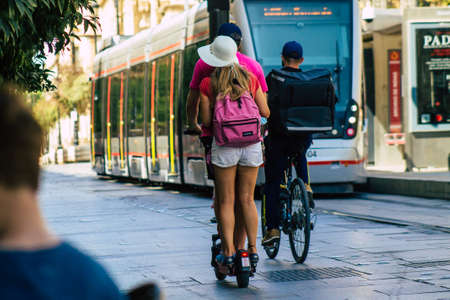 Seville Spain August 21, 2021 People rolling with an electric scooter in the streets of Seville,...