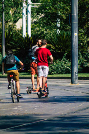 Seville Spain September 04, 2021 People rolling with an electric scooter in the streets of Seville, operating with a small utility internal combustion engines and a deck in the centerの写真素材