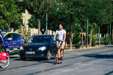 Seville Spain September 04, 2021 People rolling with an electric scooter in the streets of Seville, operating with a small utility internal combustion engines and a deck in the centerの写真素材