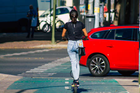 Seville Spain September 22, 2021 People rolling with an electric scooter in the streets of Seville, operating with a small utility internal combustion engines and a deck in the centerの写真素材