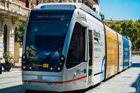 Seville Spain September 18, 2021 Modern electric tram for passengers rolling through the streets of Seville during the coronavirus outbreak hitting Spain, wearing a mask is mandatoryのeditorial素材