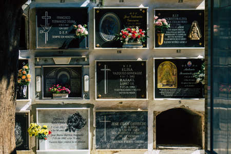 Seville Spain September 21, 2021 Typical graves in a Christian cemetery of the municipality of Carmona in Andalusia in southern Spain, the graves are made in the depth of a wall and richly decoratedのeditorial素材