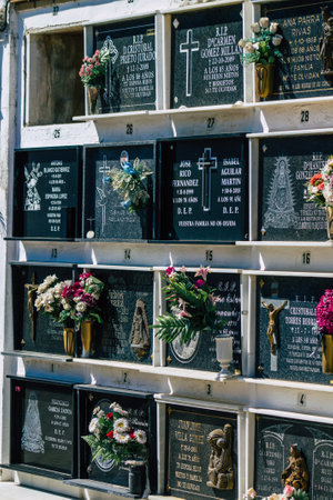 Seville Spain September 21, 2021 Typical graves in a Christian cemetery of the municipality of Carmona in Andalusia in southern Spain, the graves are made in the depth of a wall and richly decoratedのeditorial素材