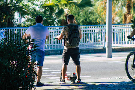 Seville Spain September 18, 2021 People rolling with an electric scooter in the streets of Seville, operating with a small utility internal combustion engines and a deck in the centerのeditorial素材